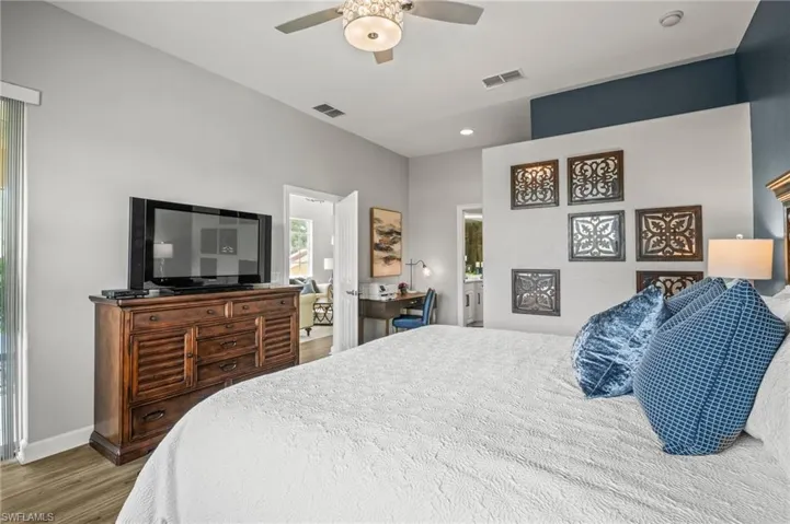 Bedroom featuring wood finished floors, an office area, a ceiling fan, and recessed lighting