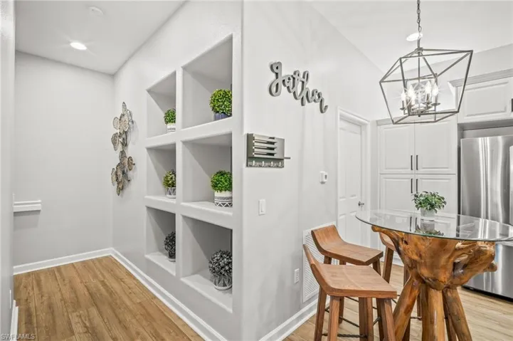 Dining space featuring a chandelier, light wood finished floors, built in features, and recessed lighting