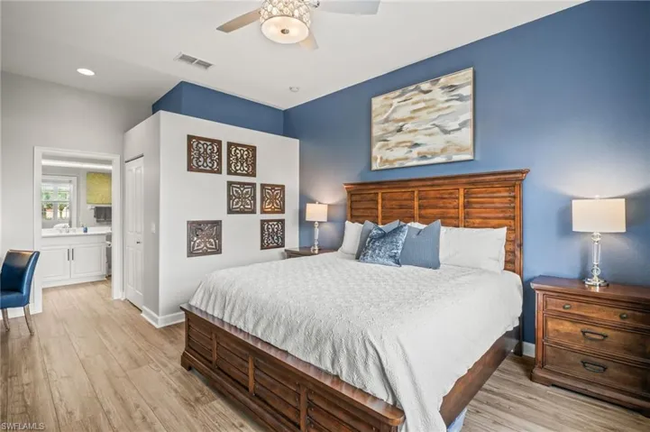 Bedroom featuring light wood-style flooring, connected bathroom, a closet, and a ceiling fan