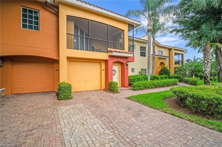 View of property featuring an attached garage, stucco siding, and driveway
