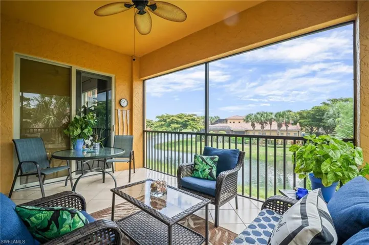 Sunroom featuring a ceiling fan, a water view, and an outdoor living space