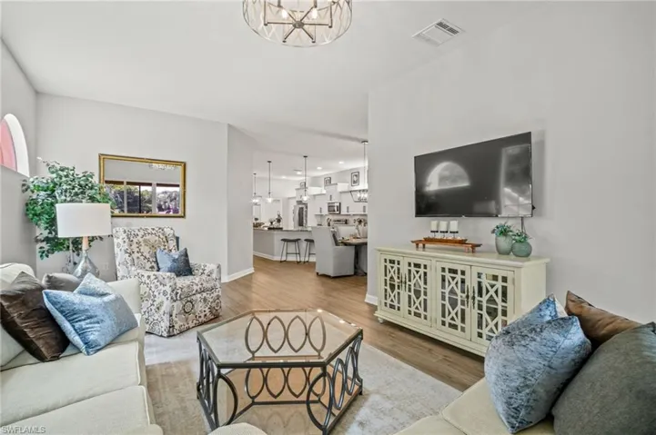 Living area with a chandelier, wood finished floors, and recessed lighting