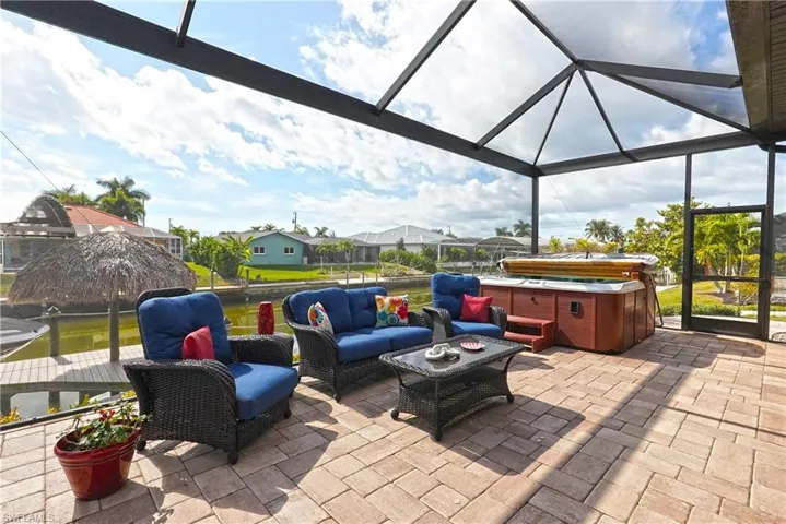 View of patio with a lanai, picture screen lanai enclosure, a hot tub, outdoor lounge area