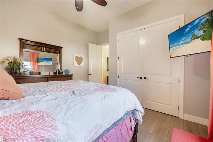 Bedroom with light wood-style flooring, a closet, and a ceiling fan