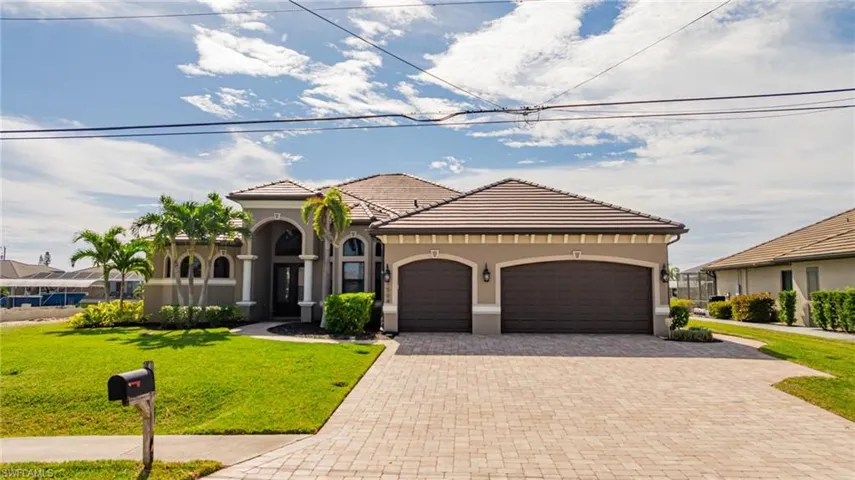 Mediterranean / spanish-style home featuring a front yard, stucco siding, decorative driveway, an attached garage, and a tiled roof