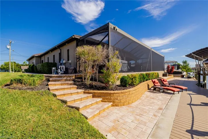 Rear view of property with glass enclosure, a patio, a yard, and a sunroom