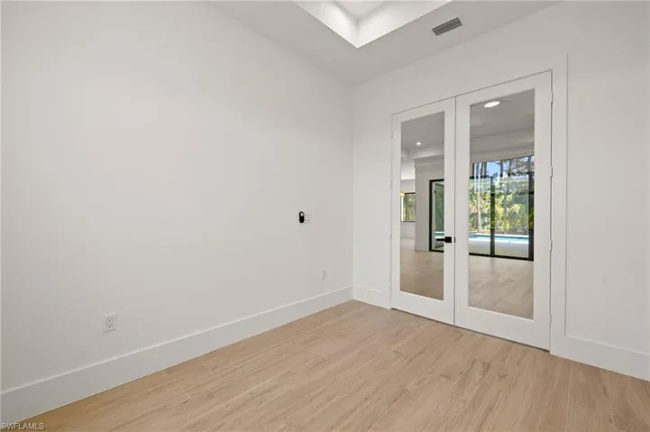 Unfurnished room with light wood-style floors, baseboards, and visible vents