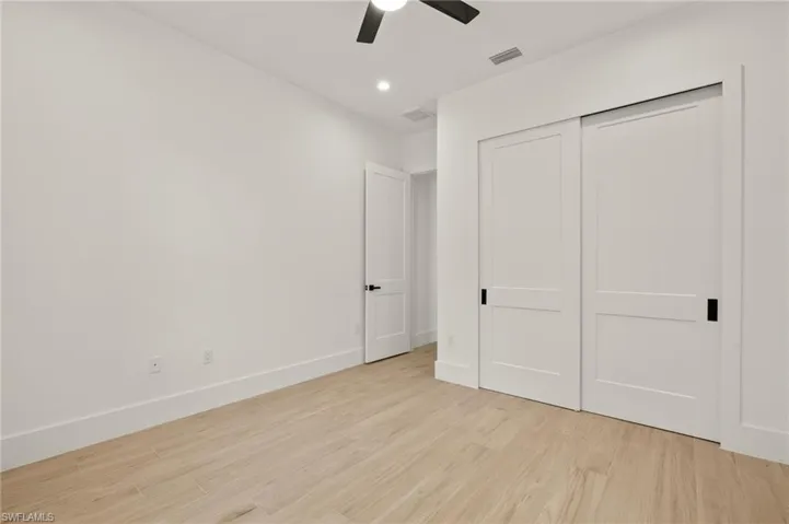 Unfurnished bedroom with visible vents, baseboards, a closet, ceiling fan, and light wood finished floors