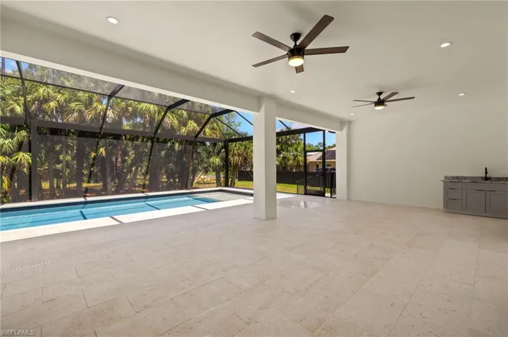 Outdoor pool with a patio area, ceiling fan, a sink, and a lanai