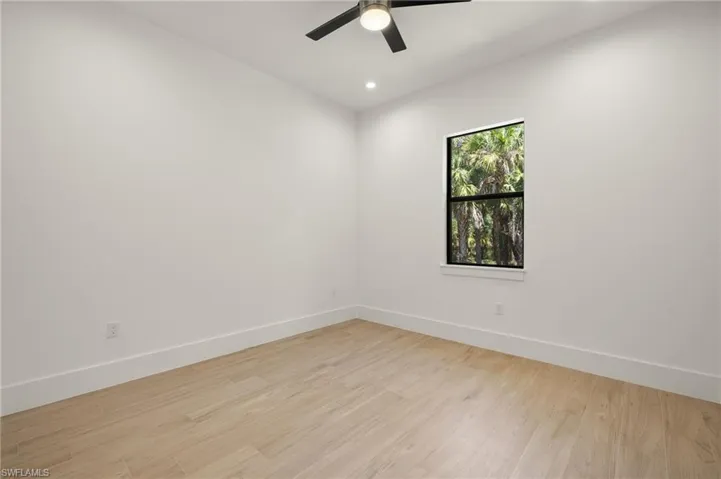 Empty room featuring light wood-style floors, baseboards, a ceiling fan, and recessed lighting