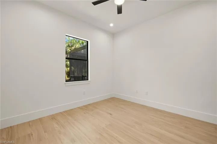Empty room with wood finished floors, ceiling fan, baseboards, and recessed lighting