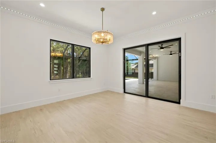 Empty room with a chandelier, light wood finished floors, baseboards, and recessed lighting