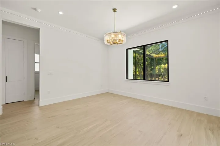 Unfurnished room featuring baseboards, light wood finished floors, an inviting chandelier, and recessed lighting