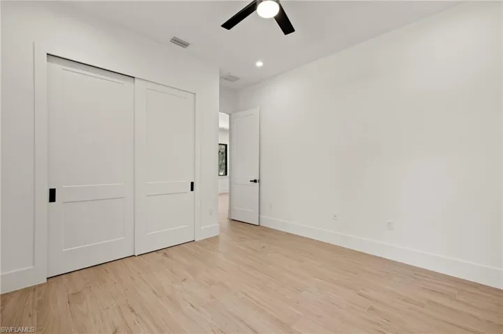 Unfurnished bedroom featuring a closet, visible vents, light wood-type flooring, and baseboards
