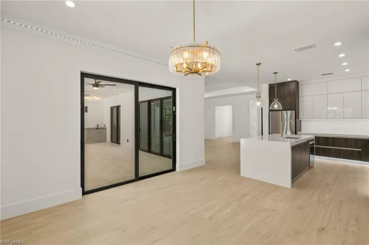 Kitchen with light countertops, backsplash, dark brown cabinets, and modern cabinets