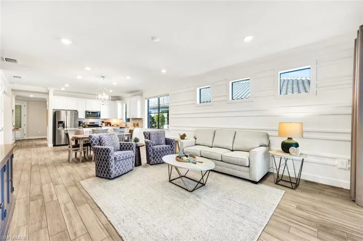 Living area featuring wood tiled floors, recessed lighting, crown molding, and a chandelier