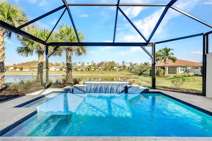 Outdoor pool featuring glass enclosure, a water view, and a sunroom