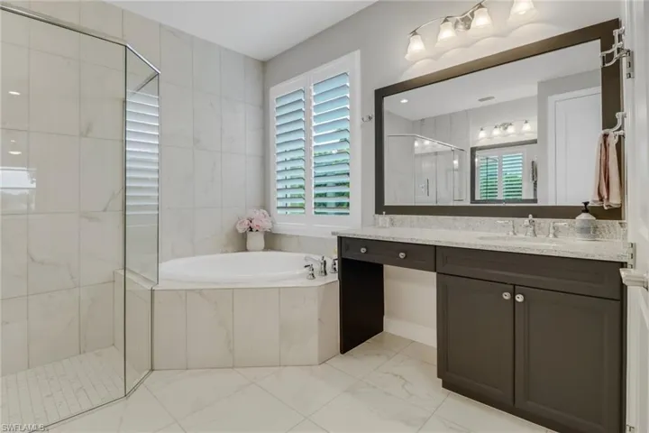 Master Bathroom featuring separate tub and shower, dual vanities.