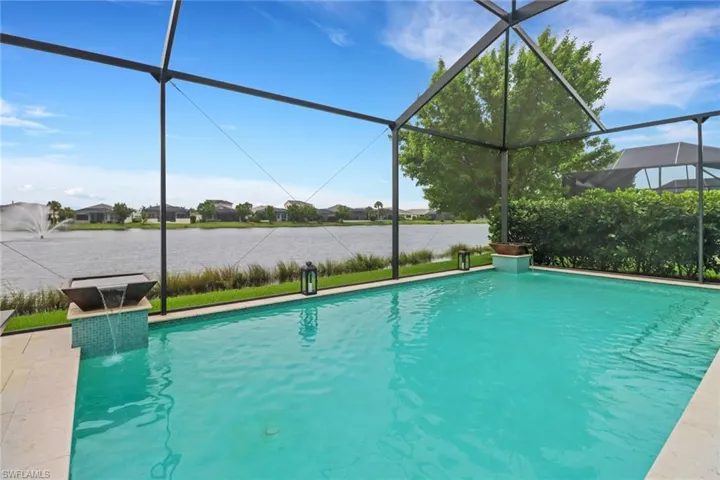 View of pool with pool water feature and a lanai