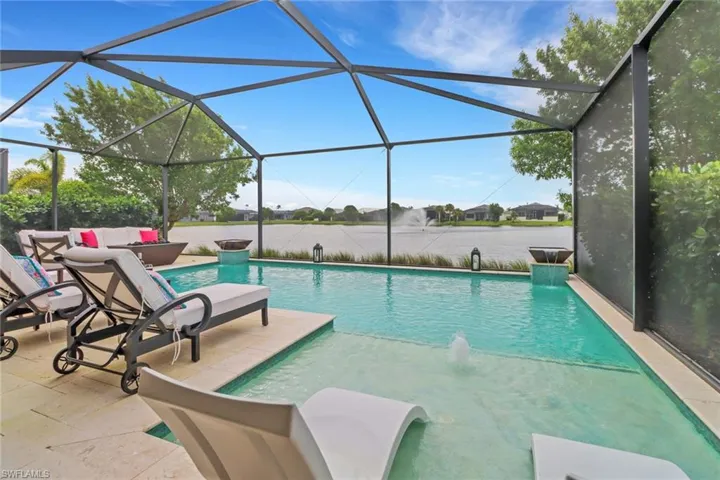 View of pool featuring a lanai, pool water feature, and a patio