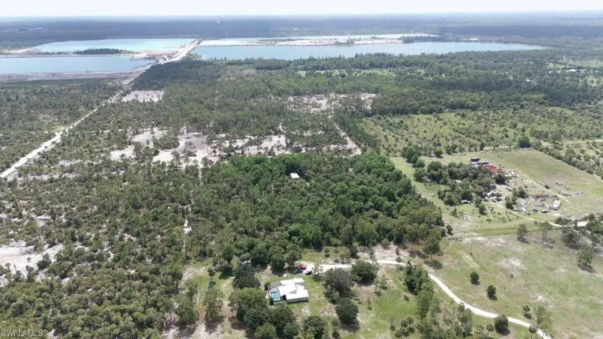Expansive rural landscape featuring a mix of mature trees, scattered clearings, and unpaved roads