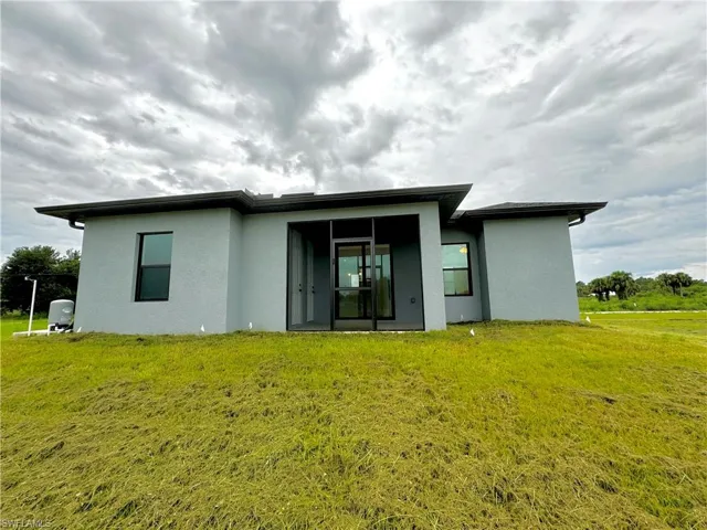 Rear view of house with a yard and stucco siding