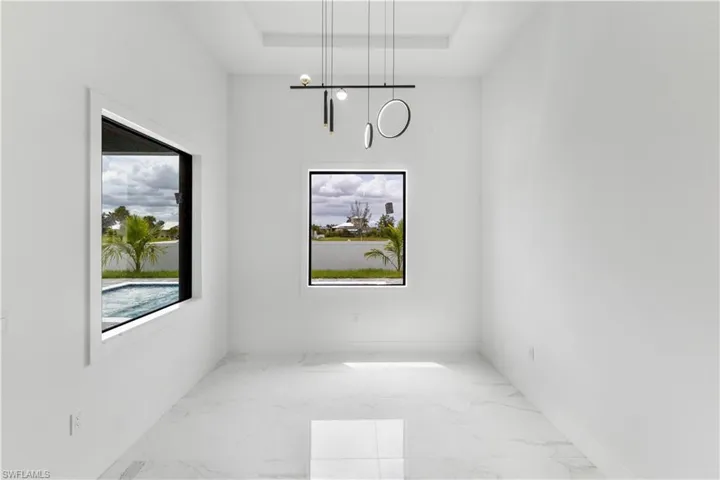 Unfurnished dining area featuring light marble finish floors and baseboards