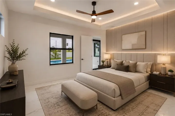 Tray ceiling with recessed lighting and a ceiling fan, accent wall with integrated backlighting, a rectangular window, and tile flooring
