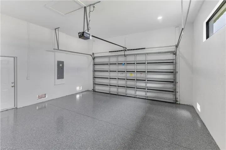 Garage featuring electric panel and a garage door opener