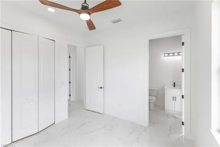 Unfurnished bedroom with a closet, light marble finish flooring, a ceiling fan, and recessed lighting