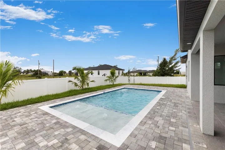 View of swimming pool featuring patio surround and a fenced backyard