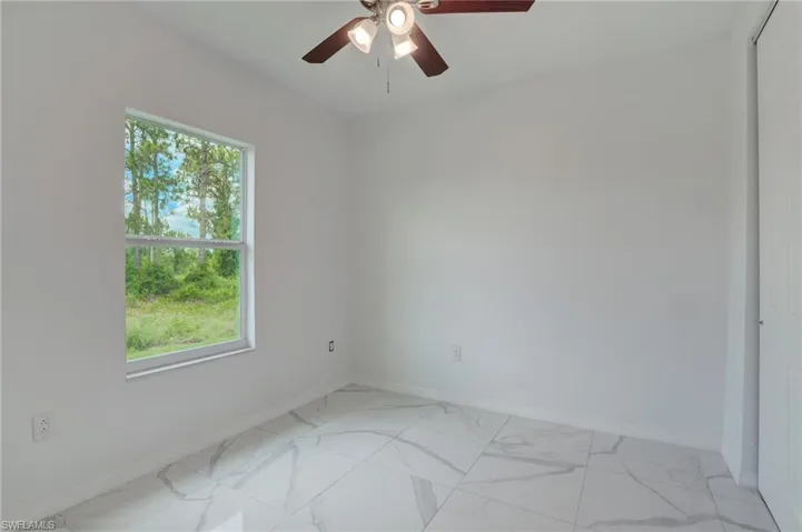 Bathroom featuring tile walls, oversized vanity, toilet, a walk in tile shower, and tile flooring