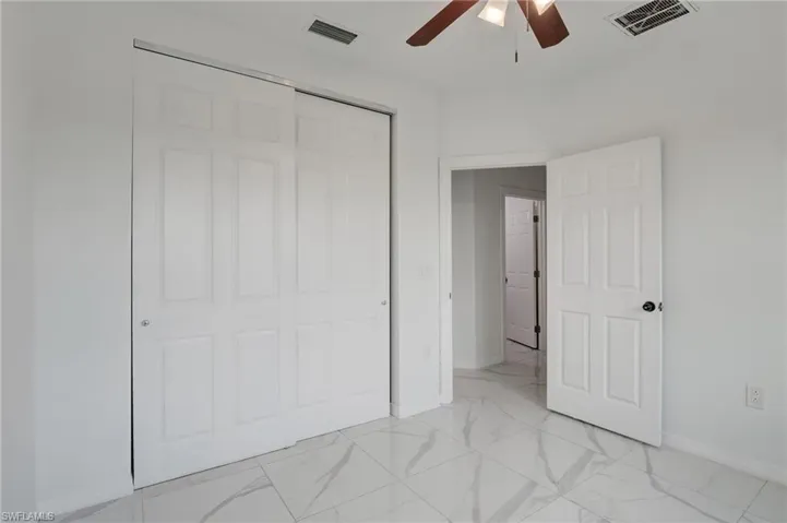 Empty room featuring ceiling fan and light tile flooring