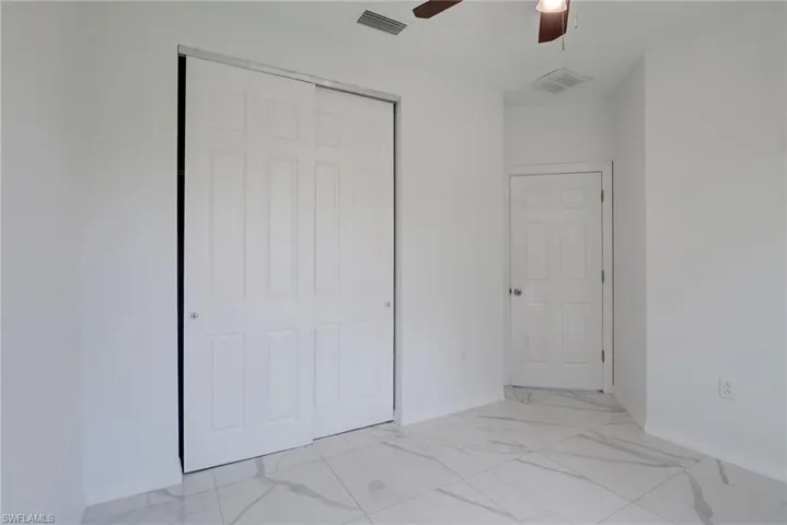 Tiled empty room featuring ceiling fan