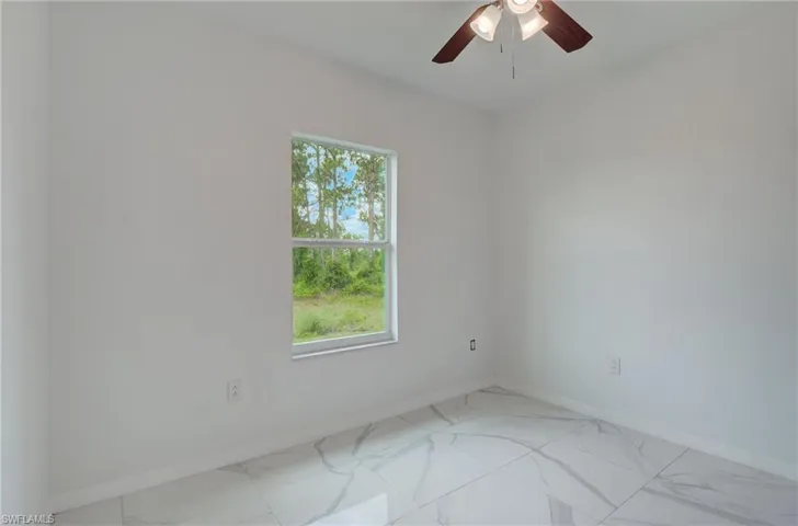 Unfurnished bedroom with a closet, ceiling fan, and light tile floors