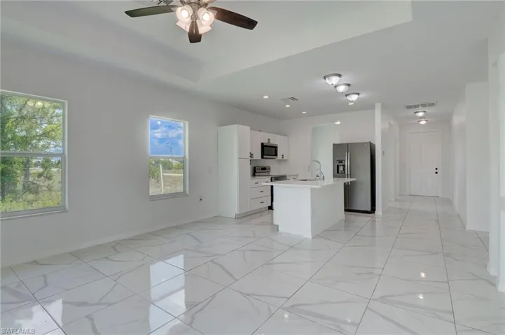Kitchen featuring stainless steel appliances, a wealth of natural light, sink, and light tile floors