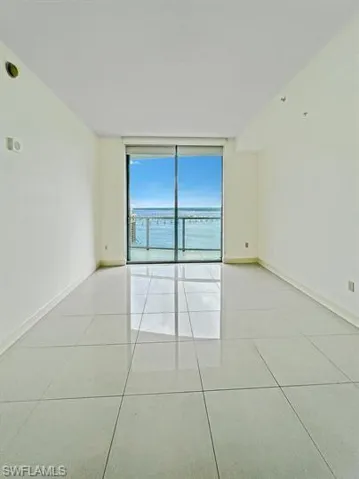 Unfurnished room with light tile patterned flooring and expansive windows