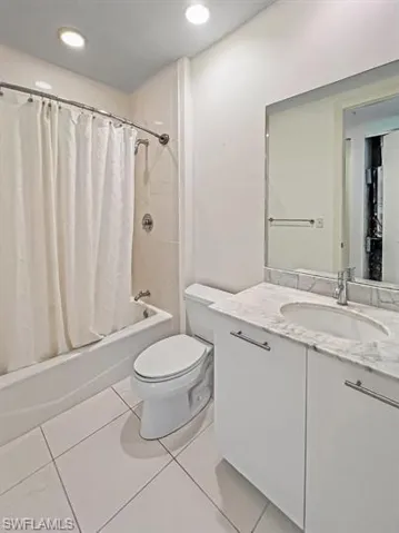 Full bath with shower / tub combo, vanity, light tile patterned floors, and recessed lighting