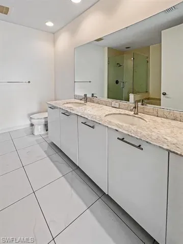Bathroom featuring a stall shower, light tile patterned floors, and recessed lighting