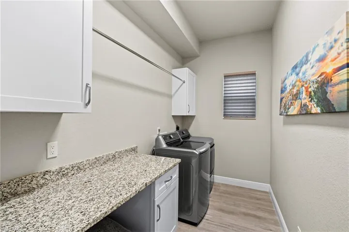 The laundry room has cabinets, a hanging rack and folding space.  There is also a closet in this room not shown in this photo.