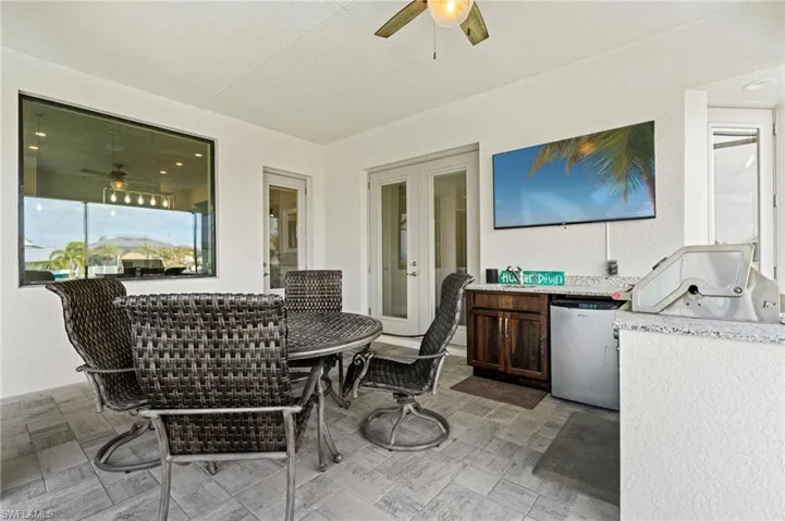 Dining area and outdoor kitchen in the lanai under truss for shade and accommodates an outdoor TV, all included in the price of the house.