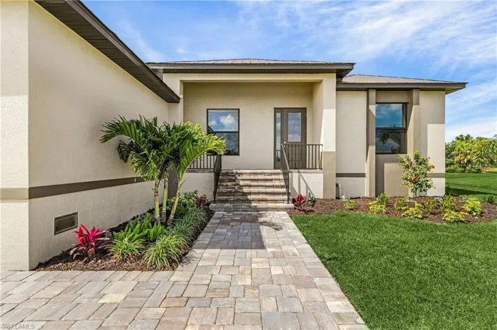 View of exterior entry featuring a lawn