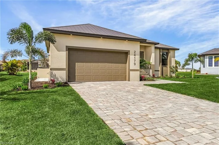View of front facade featuring a garage and a front lawn