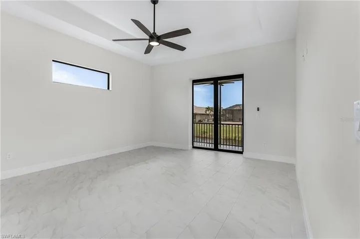 Tiled spare room with a wealth of natural light and ceiling fan