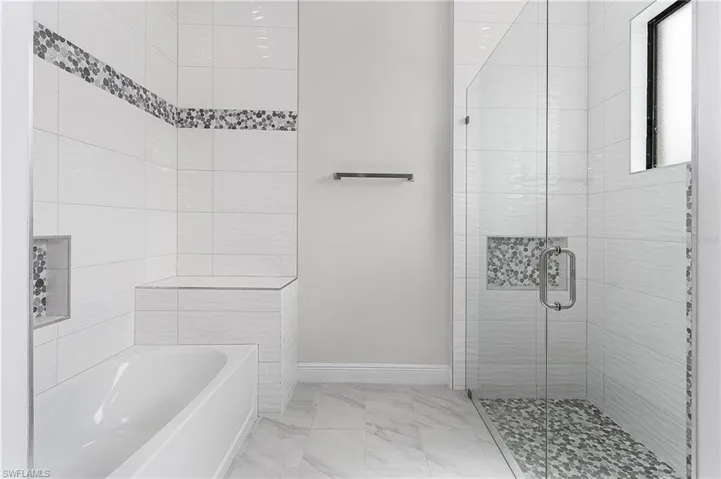 Bathroom with tile walls, shower with separate bathtub, and tile patterned floors