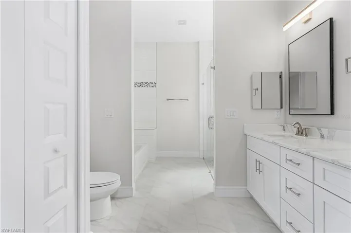 Bathroom with vanity, toilet, and tile patterned floors