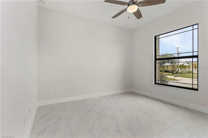 Tiled empty room with ceiling fan
