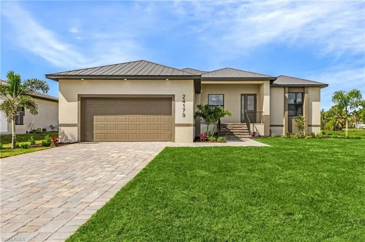View of front of home featuring a garage and a front yard