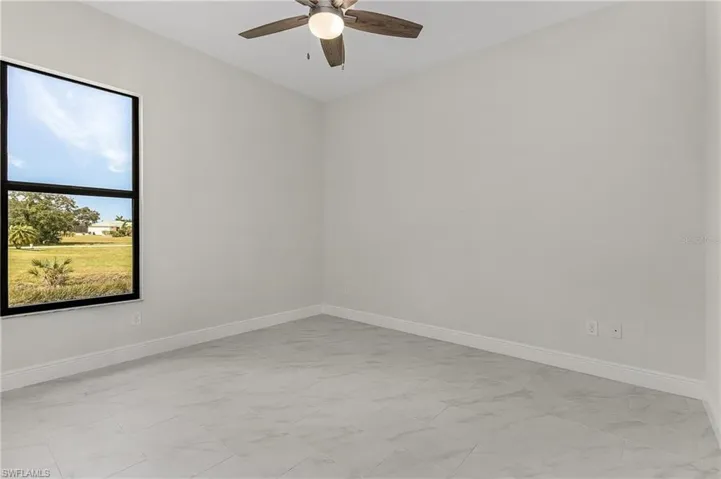 Spare room with light tile patterned floors and ceiling fan