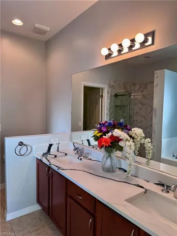 Bathroom with tile patterned floors, vanity, and separate shower and tub